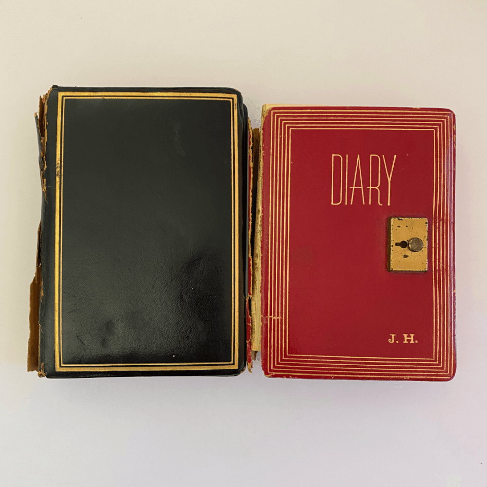 A black and red diary (left and right) The red diary has the initials J.H. on the left right hand corner