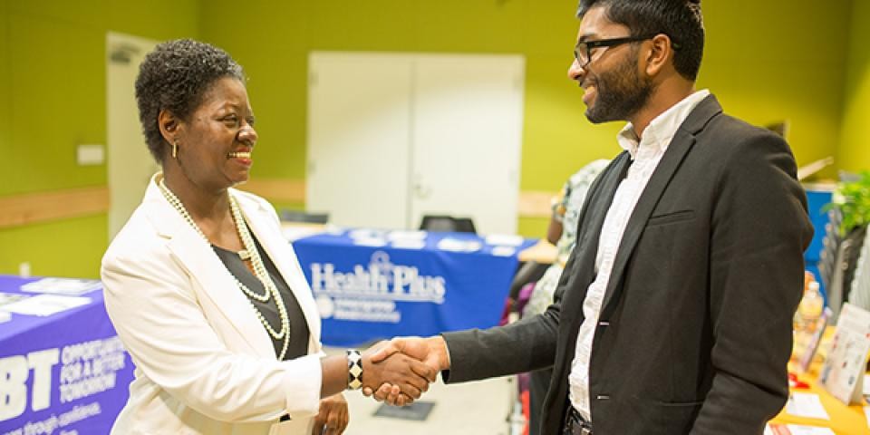 Two people shaking hands in suits.