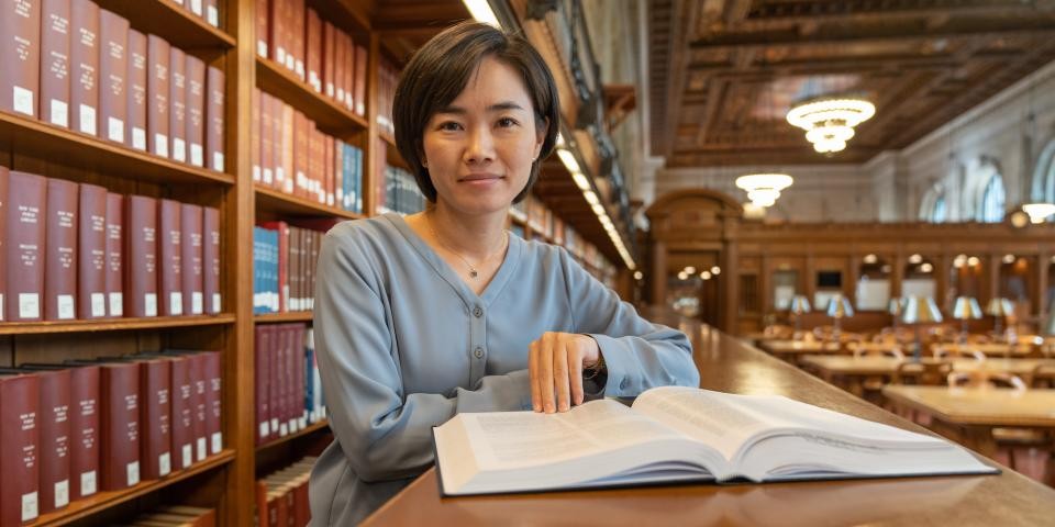 A researcher looks at a book in the Rose Main Reading Room.