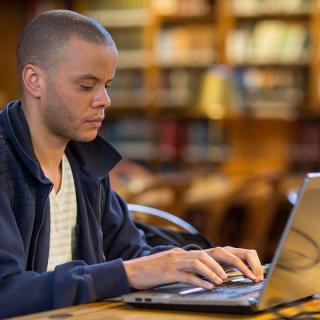 A  library patron sits at a laptop