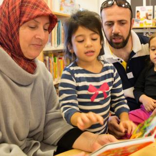 Family of Four reading a board book