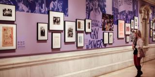 photograph of woman looking at frames on wall