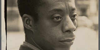 Photographic portrait of James Baldwin.