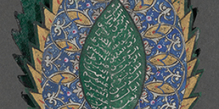 Close-up of one half of an open Qur’an written on green pages shaped like leaves. The pages have a decorative border of blue, red, gold, and silver ink surrounding silver writing oriented on sloping double columns that suggest the veins of a leaf