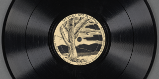 Black record with a round, central, off-white label featuring title We Shall Not Be Moved above an illustration of a bare tree in front of a body of water and mountains
