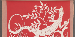 Album open to a valentine of white cut paper in the shape of a lizard and foliage backed by red paper, with handwritten text in black ink across the bottom in two columns
