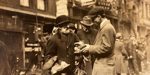 Photograph of shoes-peddler in Lower East Side talking to customers