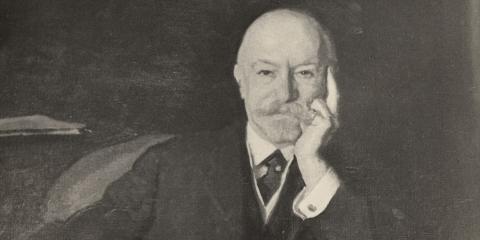 Black and white portrait of man sitting on a sofa chair. 