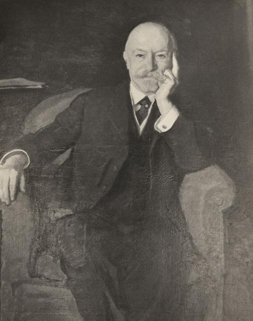 Black and white portrait of man sitting on a sofa chair. 