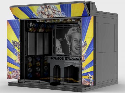 Evita set model made out of black and grey LEGOs. Colorful lights line the inside walls. The backdrop features a photo of Evite, and the proscenium features blue and yellow graphics.