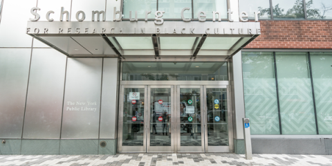 The front doors of the Schomburg Center. The words “Schomburg Center for Research in Black Culture'' is written as a metal awning above the front doors. 