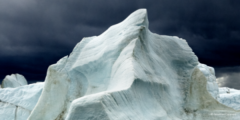 Photograph of an Arctic setting with ice jutting dramatically into the night sky.